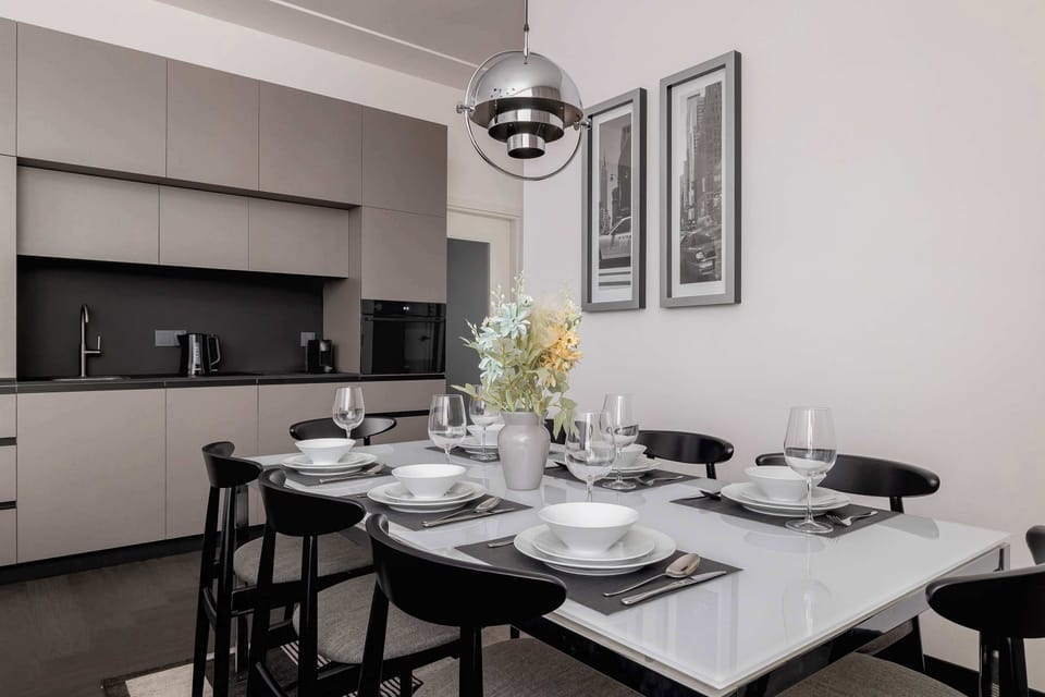 The kitchen and dining area combined, showing coordinated modern furniture and a warm atmosphere.