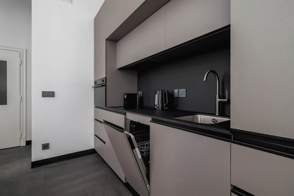 A closer look at the kitchen area, emphasizing the sink, cabinets, and clean design lines.