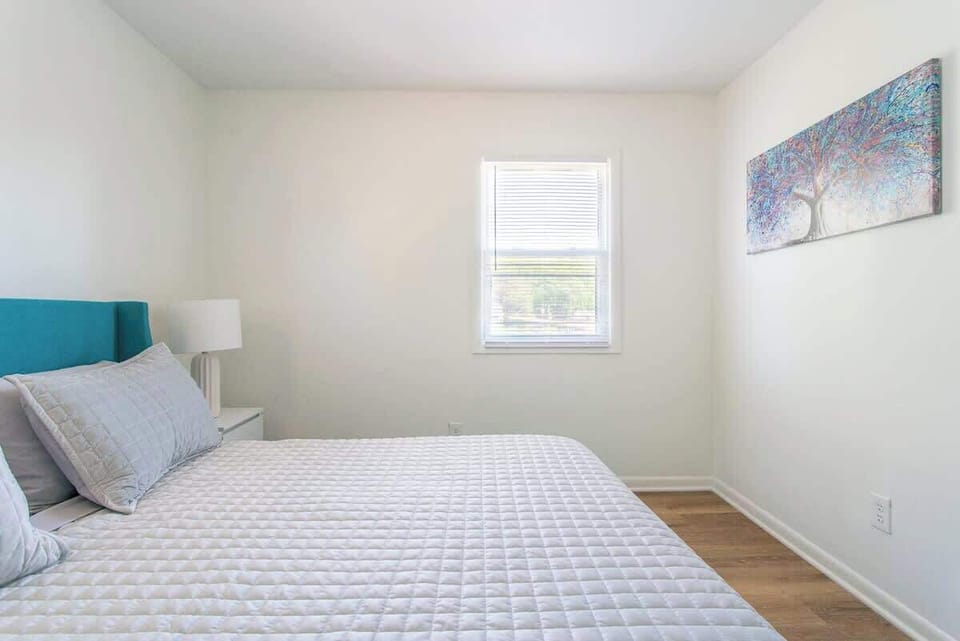 Queen-sized comfort with fresh bedding, bedside lighting, and a fan to keep the air circulating.