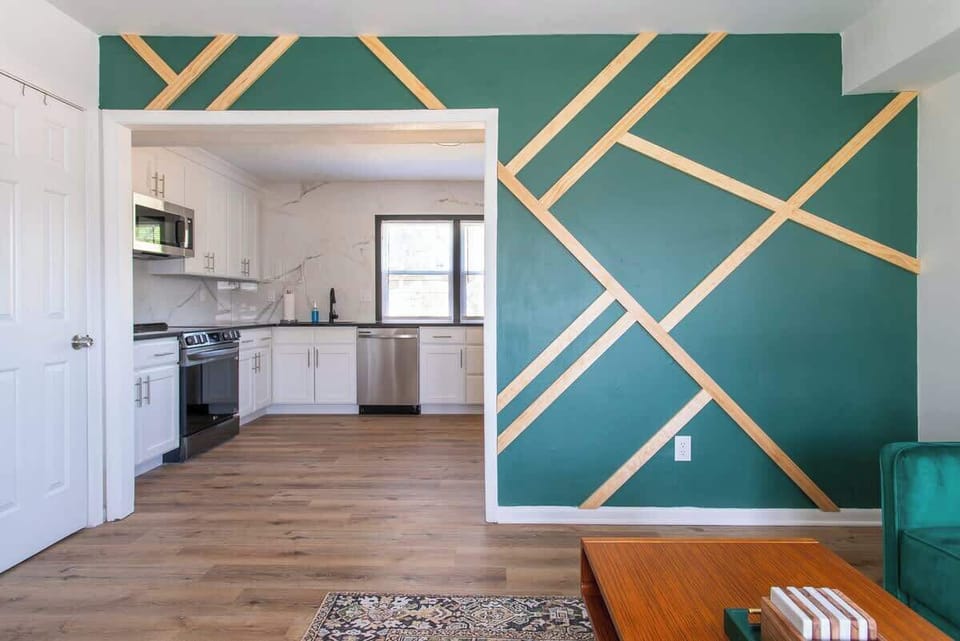 Living Room: Stylish green accents and modern kitchen await your relaxing getaway!