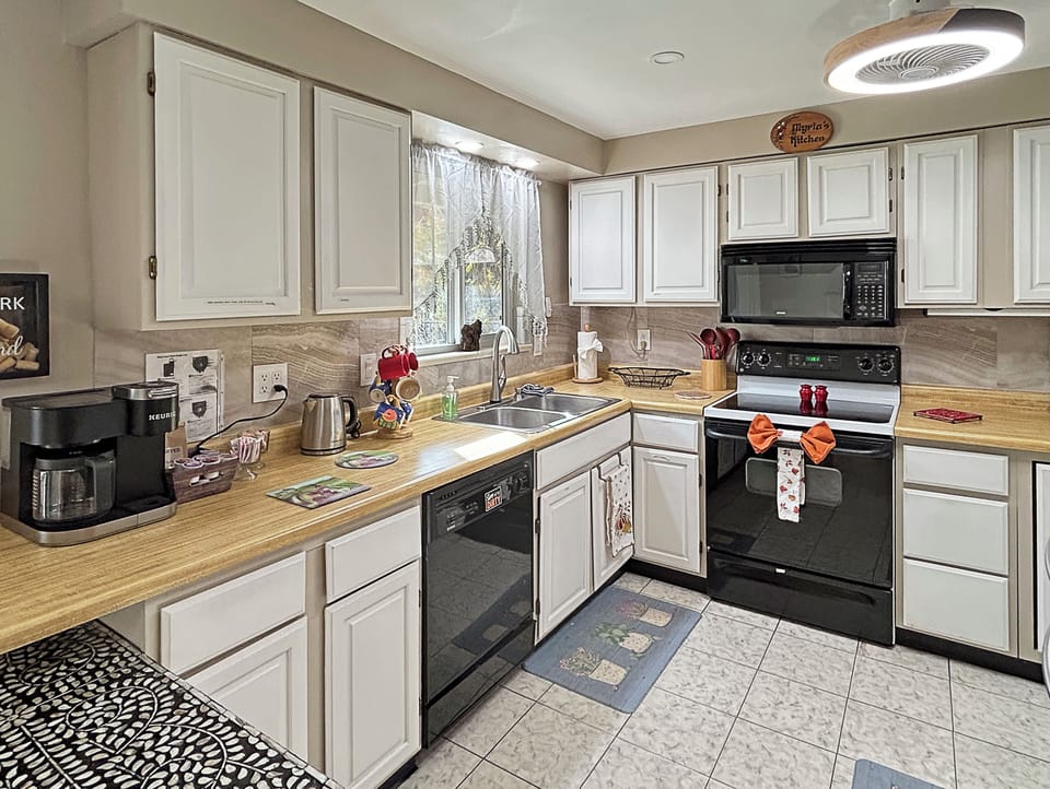 Kitchen with modern appliances, spacious counters, and cozy bar.