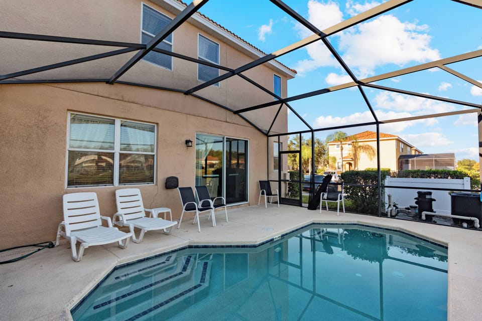 Step outside to your private oasis featuring a sparkling pool and comfy lounge chairs. The screened enclosure offers stunning sky views while keeping insects away, ideal for your relaxing afternoons.