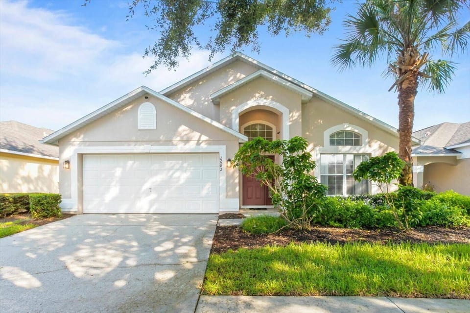 Step into a stylish exterior framed by lush landscaping and a welcoming front porch. The elegant architectural details and warm, neutral tones create a homey feel, inviting you to explore the comfort that awaits inside.