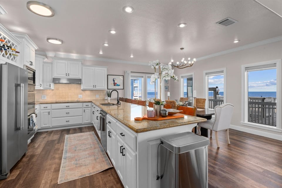 Bright and spacious kitchen with modern appliances, open layout, and views of the Gulf—perfect for group cooking.