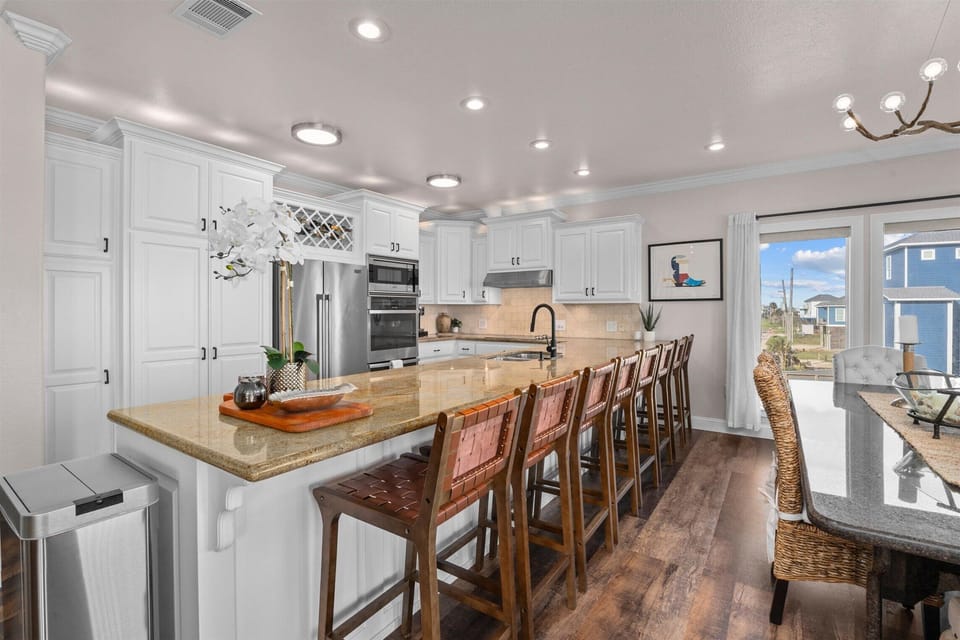Fully equipped gourmet kitchen with large island, bar seating, stainless steel appliances, and ample counter space.