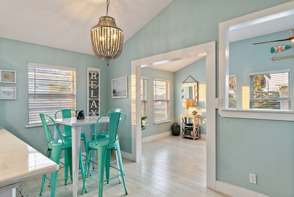 A breakfast nook has teal barstools and lots of natural light