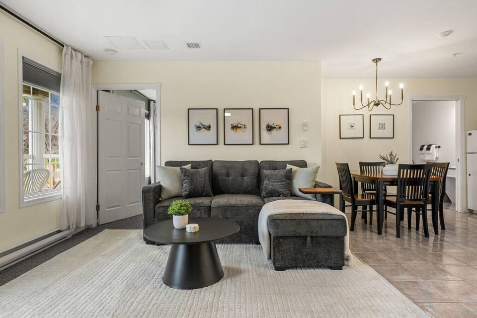 Living room with a gas-lit fireplace, smart TV, board games, walkout access to the balcony and a luxurious couch with a sleeper sofa (all bedding provided.)