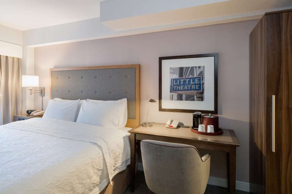 Bright king room with workspace, coffee maker, and soft bedding
