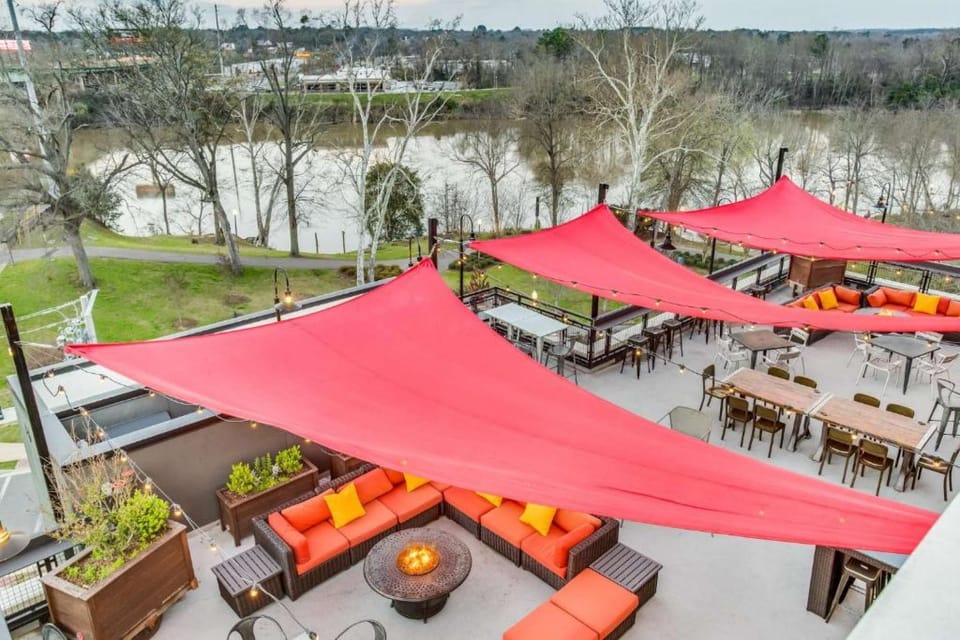 Outdoor terrace with red shades, river view, and seating areas