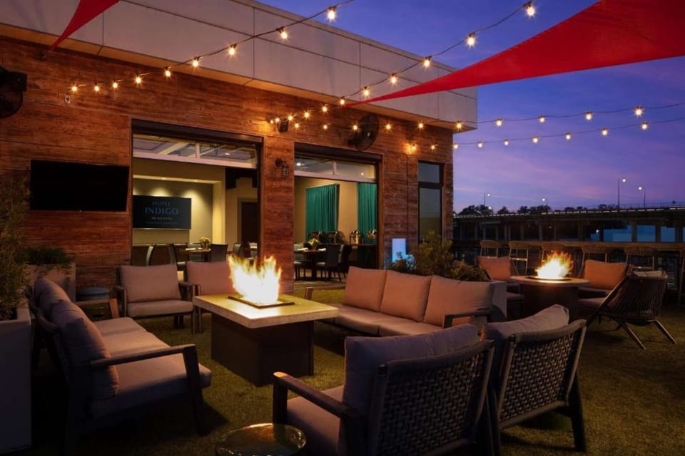 Rooftop patio with fire pits, lights, and comfy lounge seating