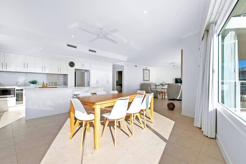 Bright, open-plan space connecting the modern kitchen and a spacious dining area.