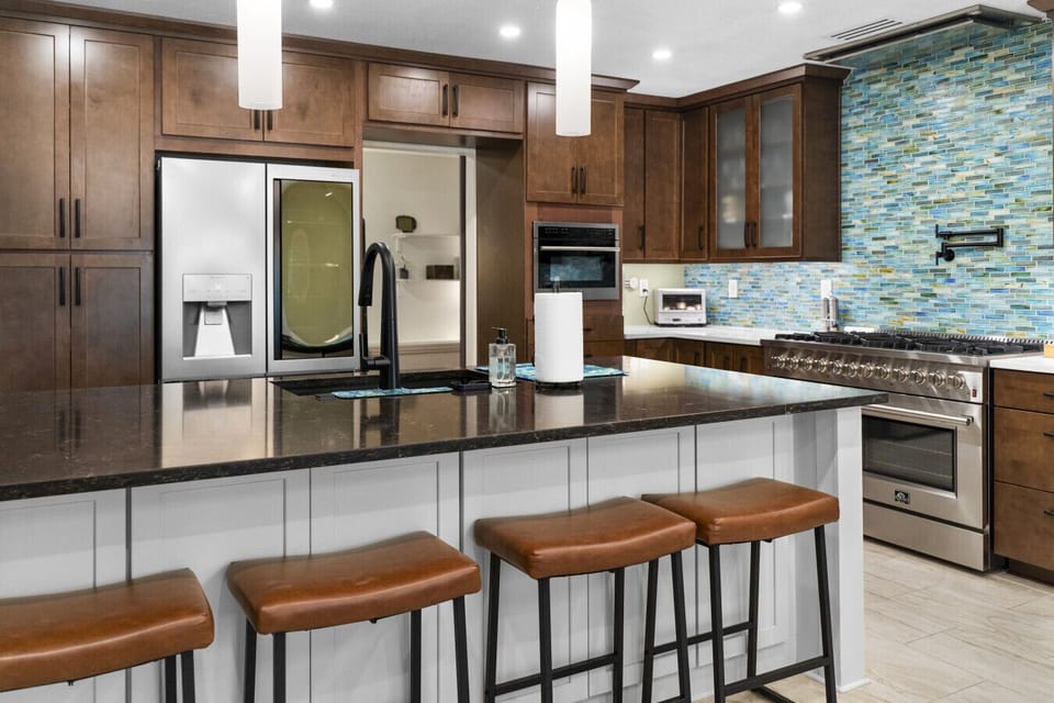 Contemporary kitchen with spacious island, bar stools, and full cooking amenities for easy meals during your stay.