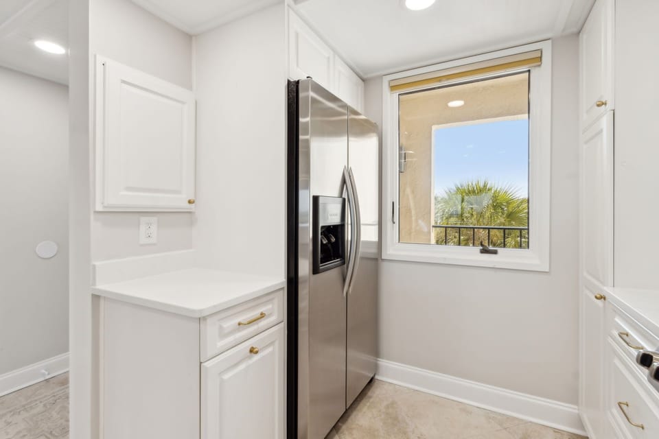 Luxury Remodeled Kitchen with Stainless Steel Appliances, Stunning White Cabinetry, Quartz Countertops, Gold Finishes and a Trendy Backsplash