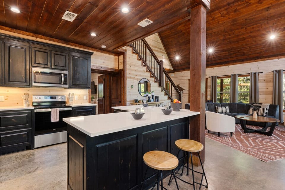 Fully stocked kitchen with large prep island, stainless appliances, and bar seating so your group can cook, snack, and socialize together in the heart of the cabin