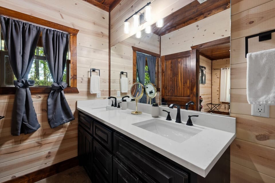 Bright ensuite with large vanity, framed mirror, and window for natural light, stocked with starter toiletries and towels for an easy, hotel-style experience