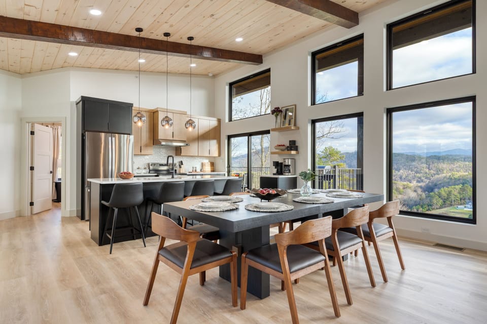 Modern kitchen and dining area with sleek finishes and expansive windows overlooking the Smoky Mountains.
