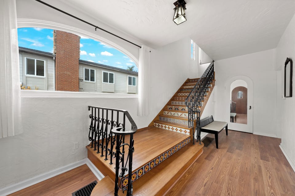 A graceful staircase welcomes you with sunlight and vintage charm