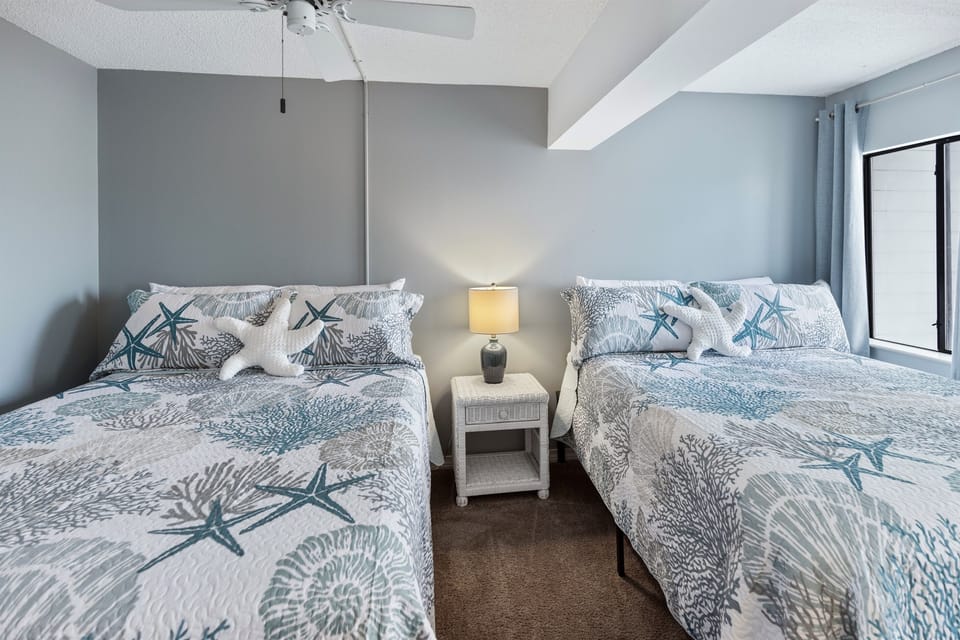 Drift off peacefully in your coastal-themed twin bedroom, where ocean-inspired bedding and soft lighting create your perfect seaside retreat.