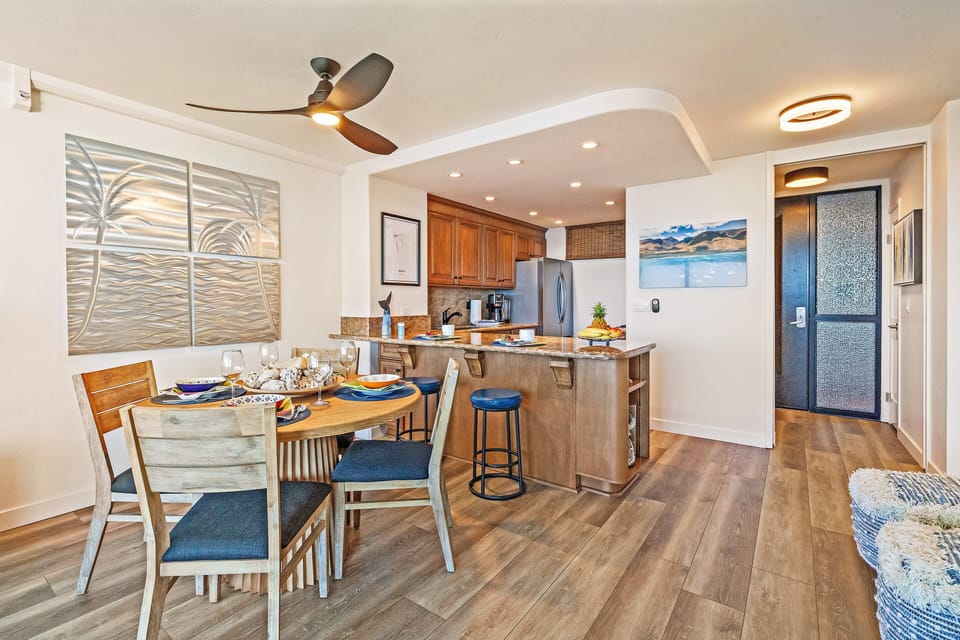 Open dining space with coastal artwork, warm wood tones, and easy access to the kitchen.