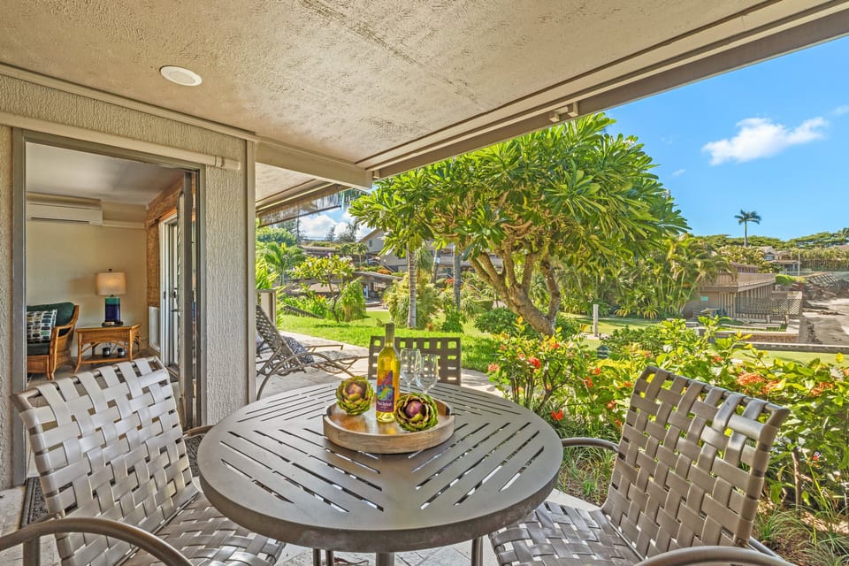 Dine outdoors on a private lanai with a shaded table and lush garden views.