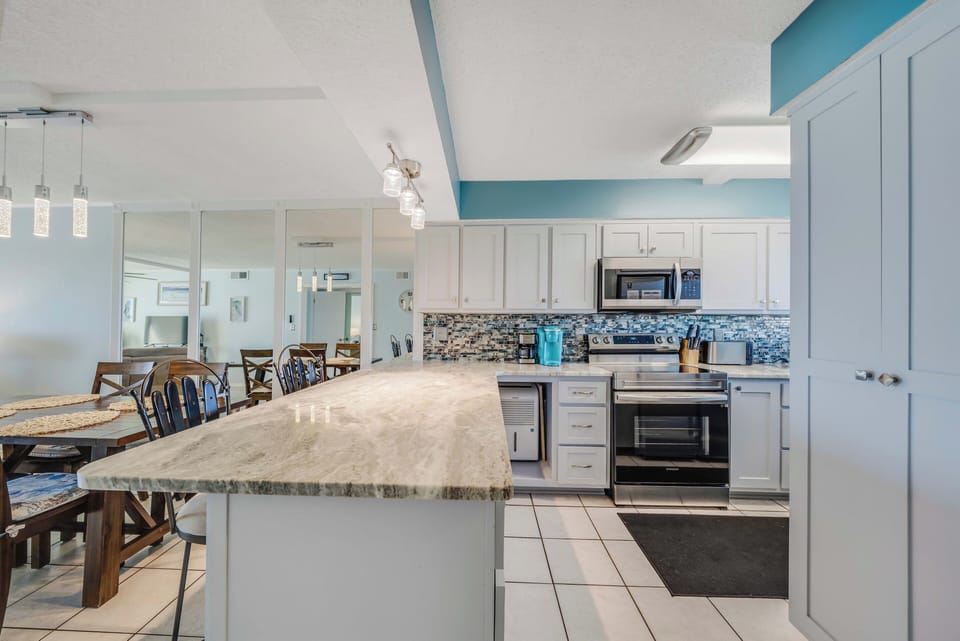 The updated, fully equipped kitchen features quartz countertops, stainless-steel appliances, and has everything you need to prepare meals for family & friends.