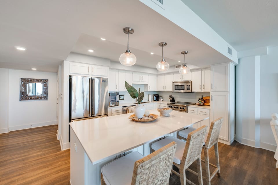 Your gourmet kitchen awaits with gleaming white countertops, stainless steel appliances, and elegant pendant lighting for memorable meal preparations.
