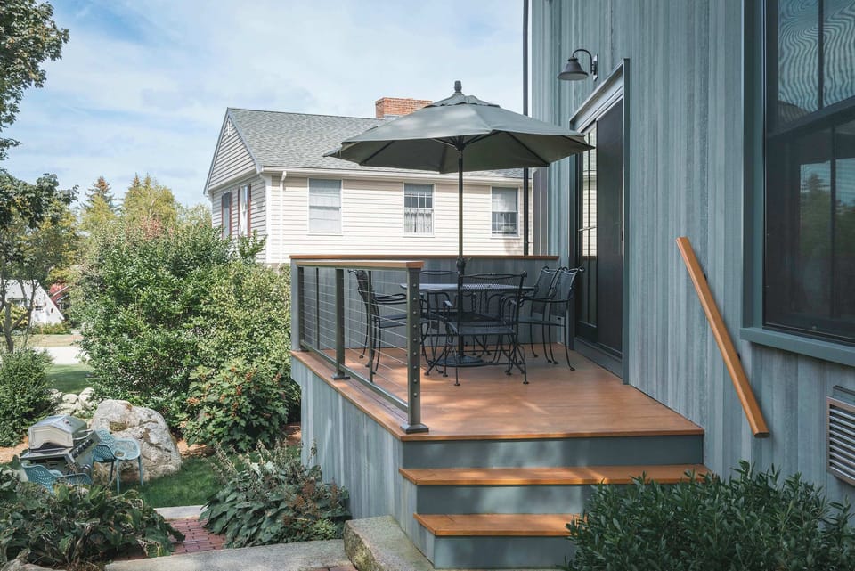 Elevated deck with umbrellas and dining space overlooking the garden