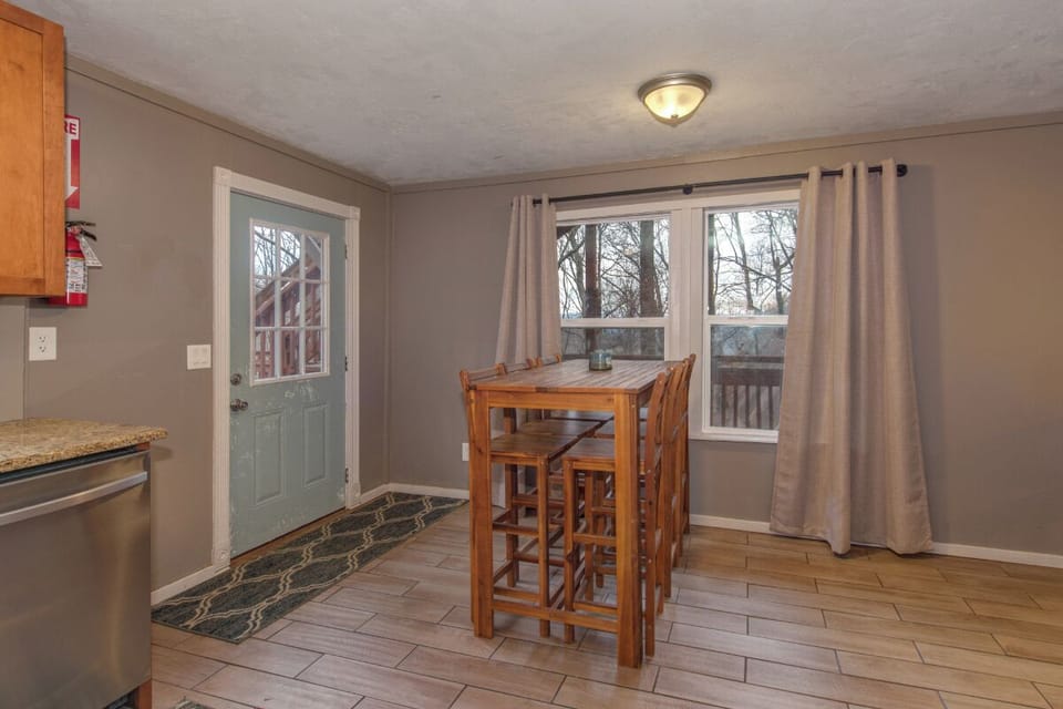Enjoy casual meals at your cozy dining table with charming forest views through bright windows.