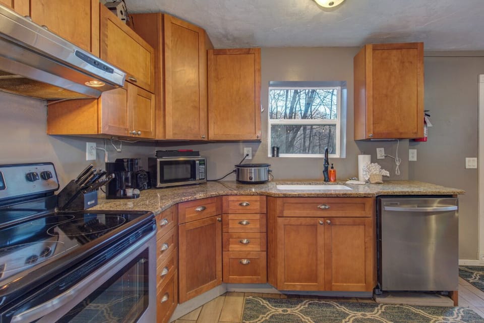 Your fully equipped kitchen awaits with modern appliances, granite counters, and warm wood cabinetry for creating memorable meals together.