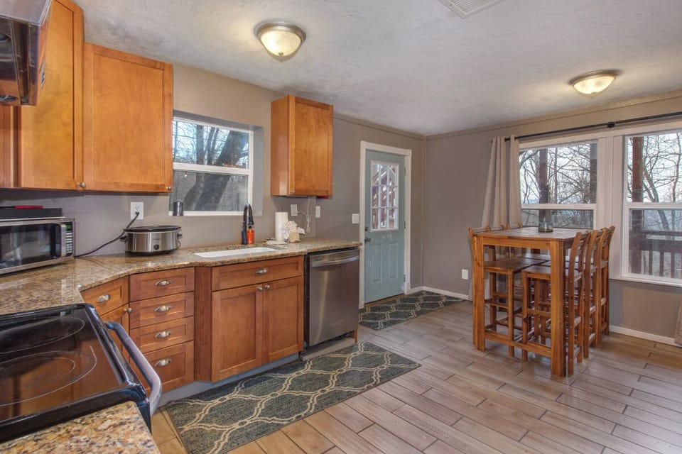 Your fully equipped kitchen awaits with warm wood cabinets, granite counters, and a cozy breakfast nook where you can enjoy morning coffee.