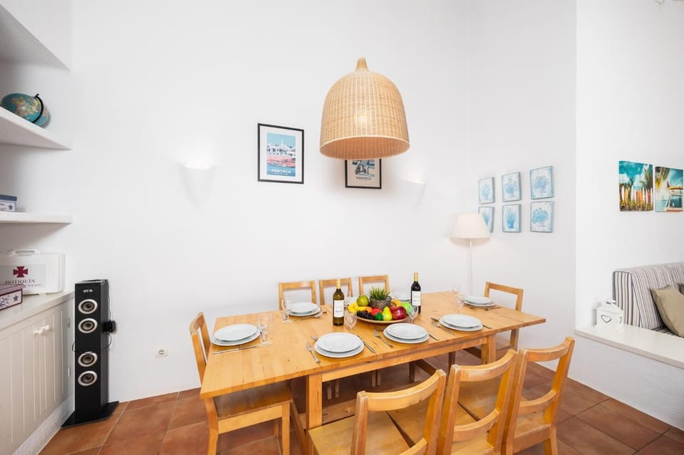 Open-plan living room with sofas, dining area, kitchen, ornamental fireplace, A/C, WiFi internet, and satellite TV