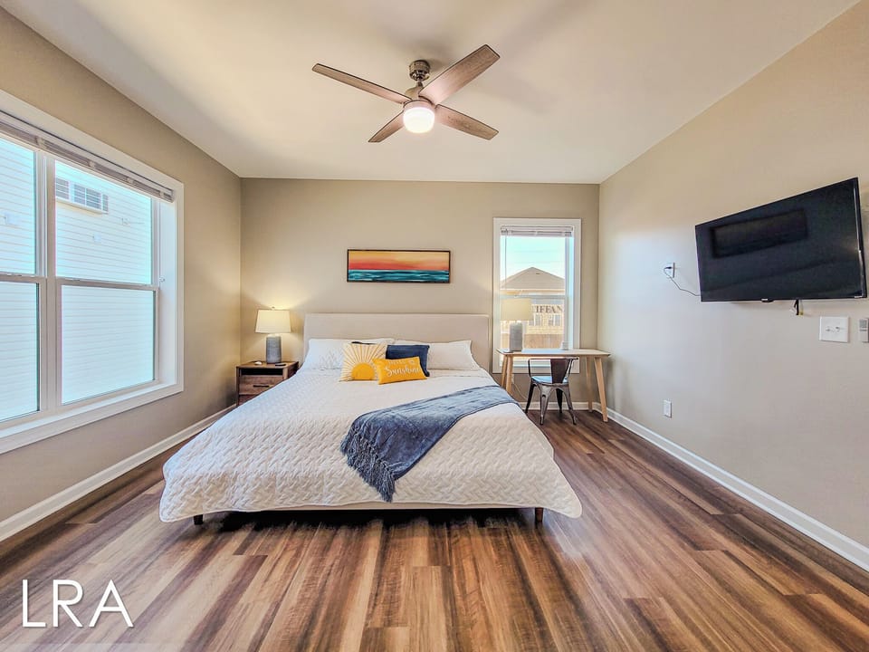 Drift off peacefully in your bright, airy bedroom with plush bedding, work desk, and ceiling fan for perfect comfort.