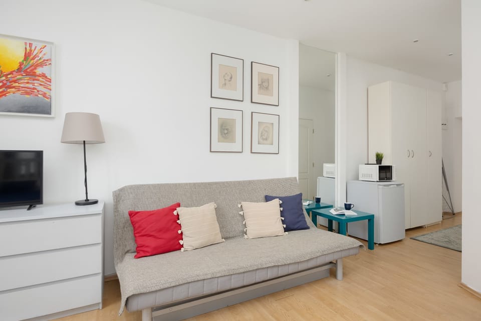 The bright living area with colourful cushions offers a cosy spot to relax, letting you enjoy a homely and uplifting atmosphere.