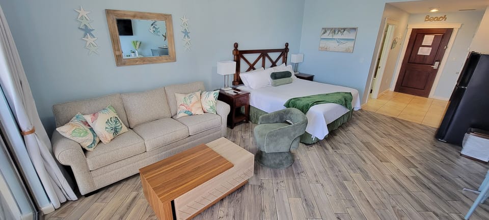 Your spacious suite combines comfort and coastal charm with a cozy sofa, queen bed, and beach-themed touches throughout.