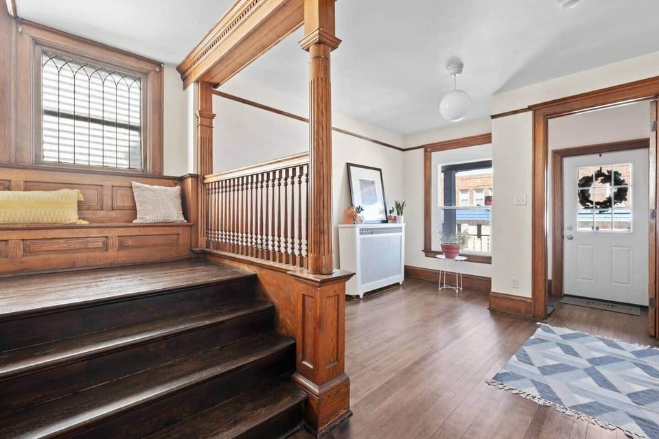 Stunning original woodwork and detailed staircase create a grand, historic feel.