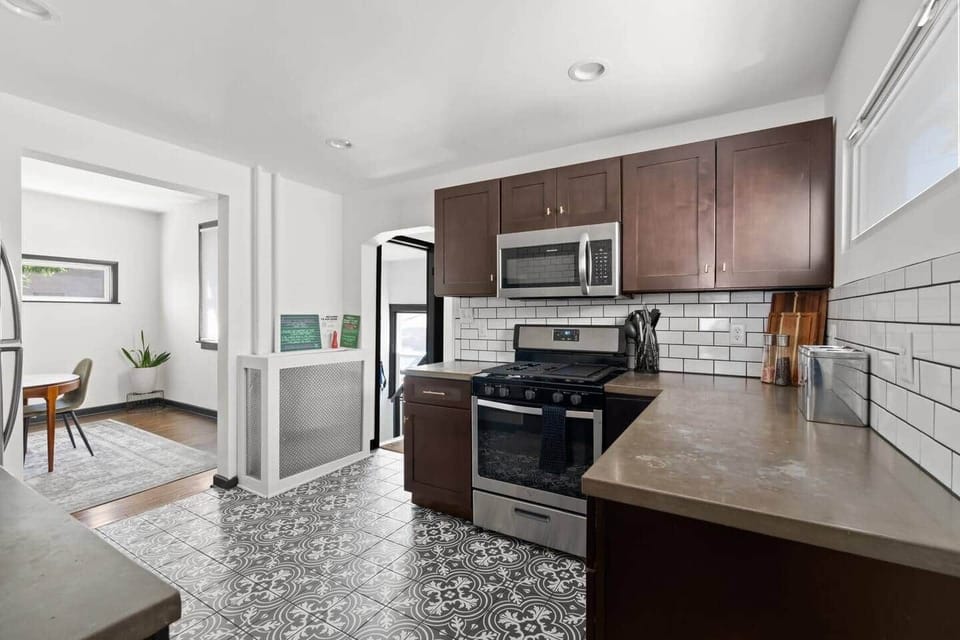 Fully equipped kitchen with stainless steel appliances, subway tile backsplash, and ample cabinet