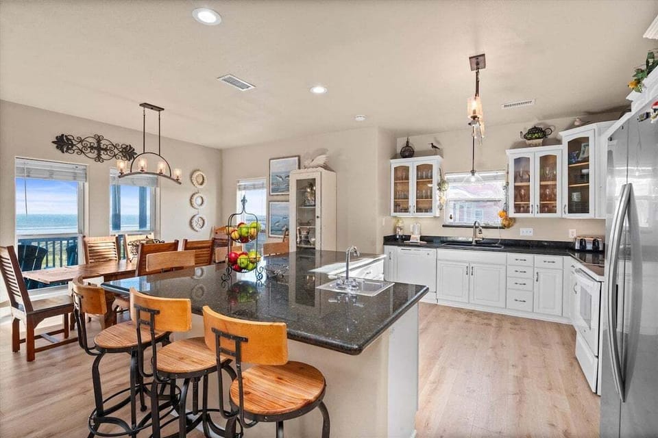 Kitchen with large island, bar seating, and modern coastal finishes