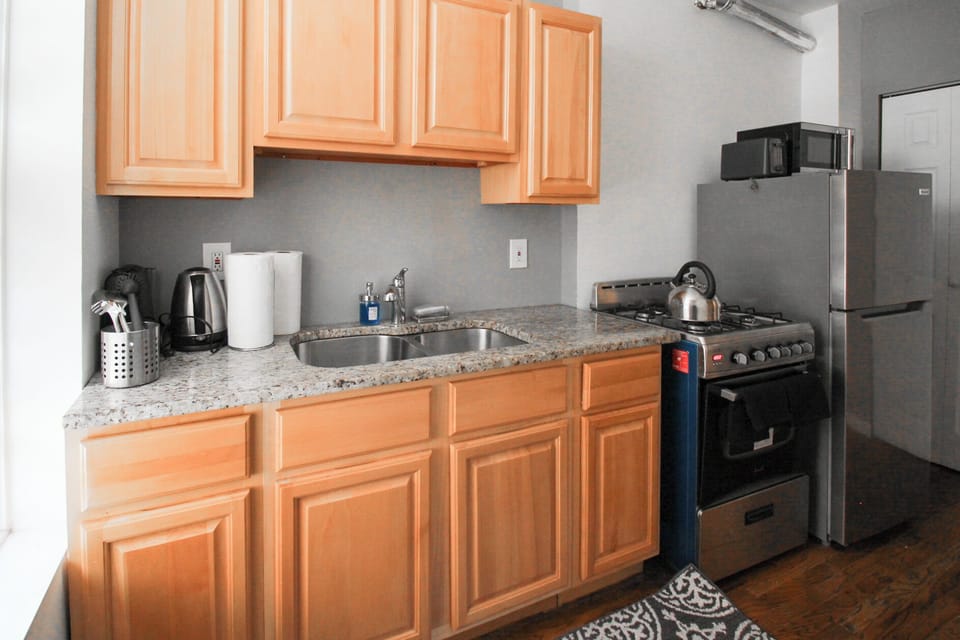 Compact kitchen with granite tops, gas range & stainless fridge