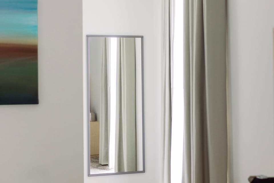 Natural light floods this inviting guestroom, showcasing its stylish decor and plush furnishings.