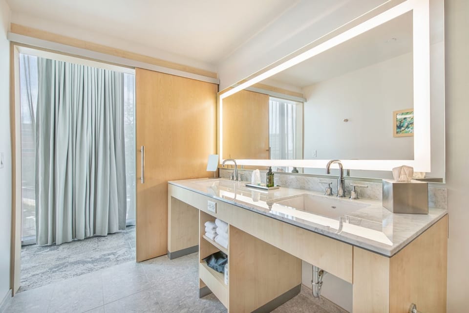 A serene escape awaits in this chic lakeside bathroom, where natural light enhances the modern elegance.