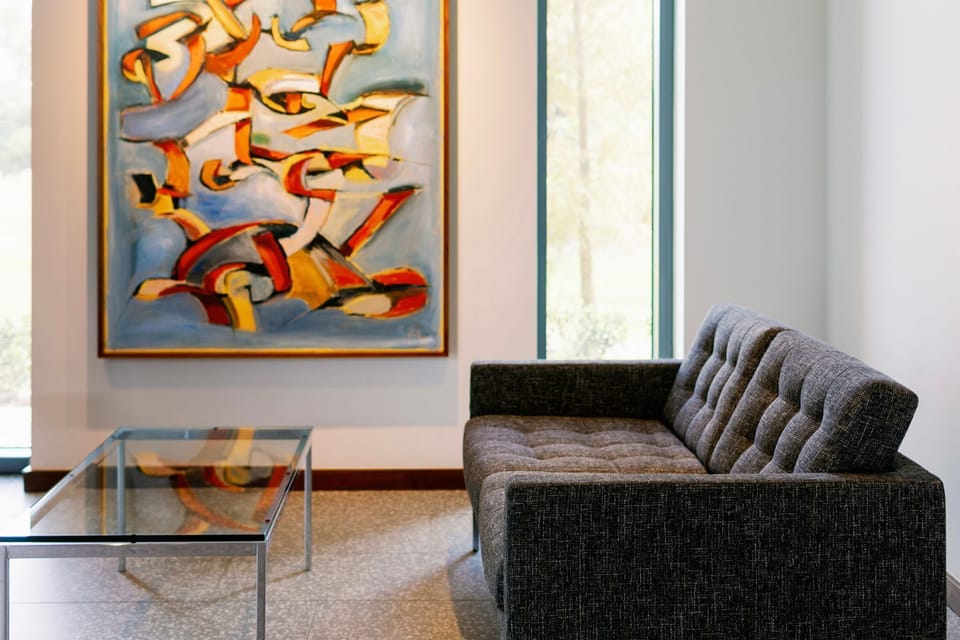 Inside, the contemporary lobby pairs a plush seating arrangement with vibrant artwork, creating an inviting space for relaxation and connection.