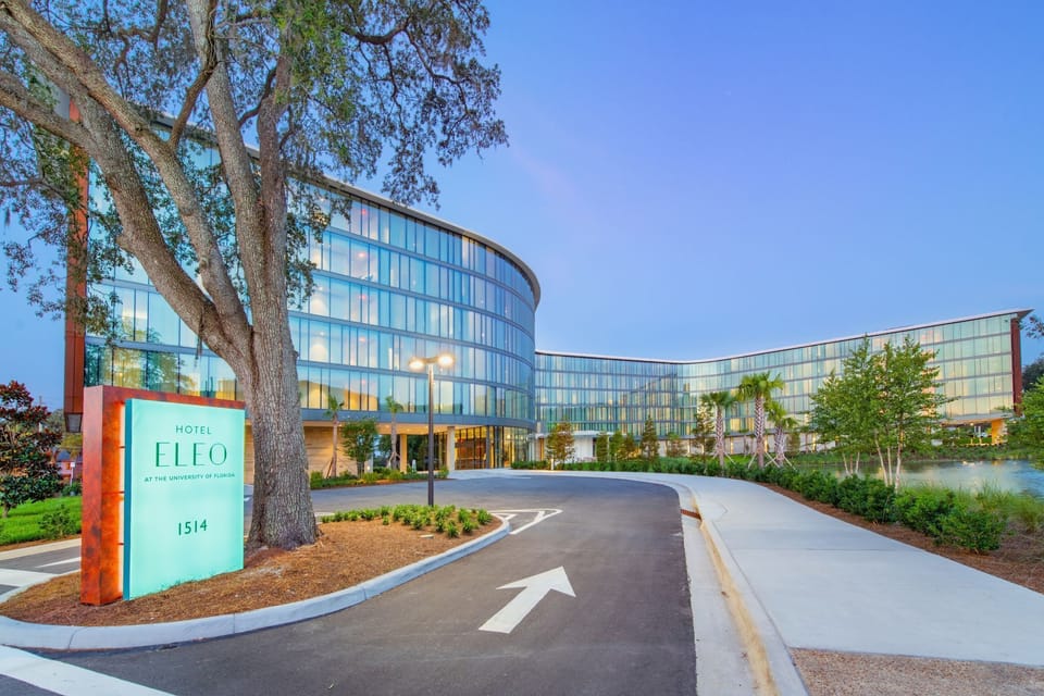 The grand entryway of Hotel ELEO welcomes guests with modern design elements and lush landscaping, setting a sophisticated yet inviting tone.