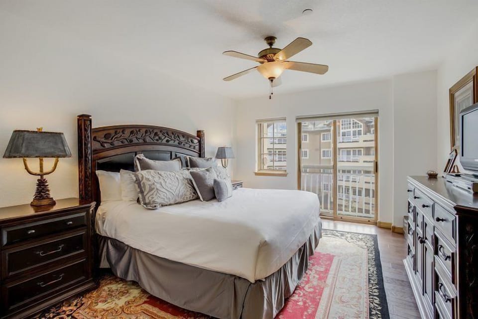 The spacious master bedroom offers comfortable furnishings and direct access to a private balcony, ensuring a restful retreat.