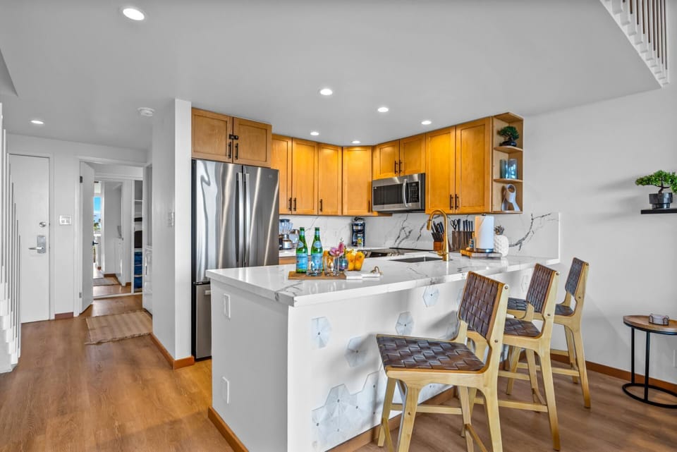 Cook with ease in the open kitchen with wood cabinetry, stainless appliances, and a roomy island that keeps prep simple.