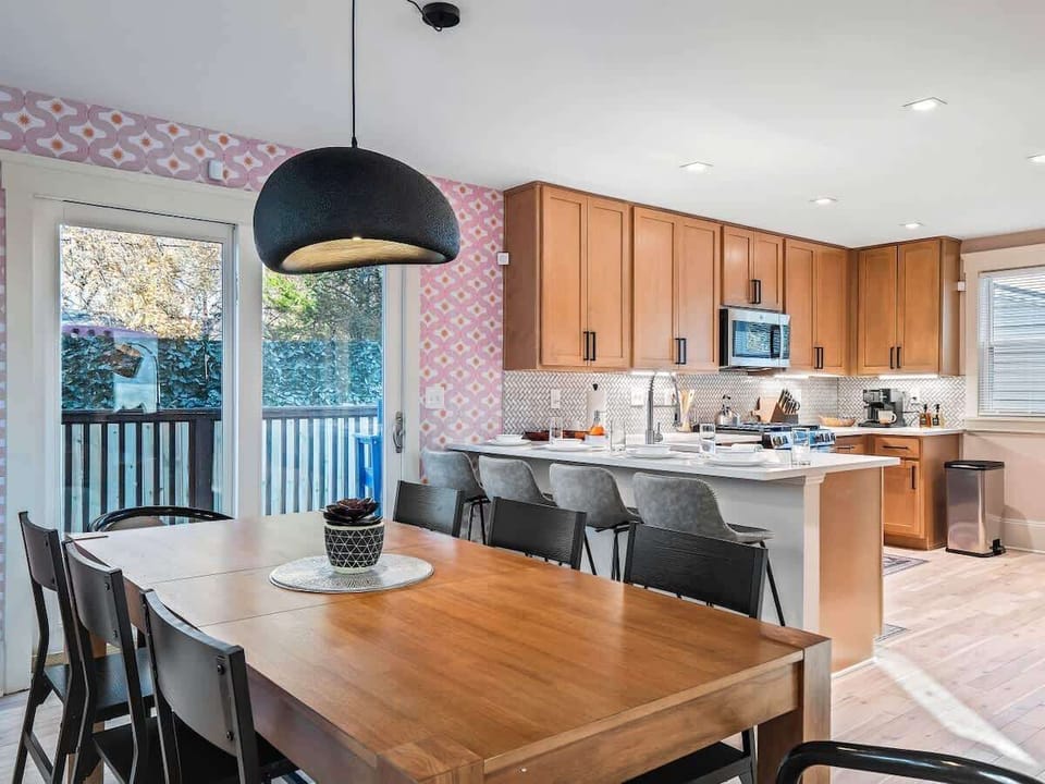 - Bright dining and kitchen area with modern décor   - Spacious Airbnb layout perfect for group meals   - Natural light creates a warm inviting stay  