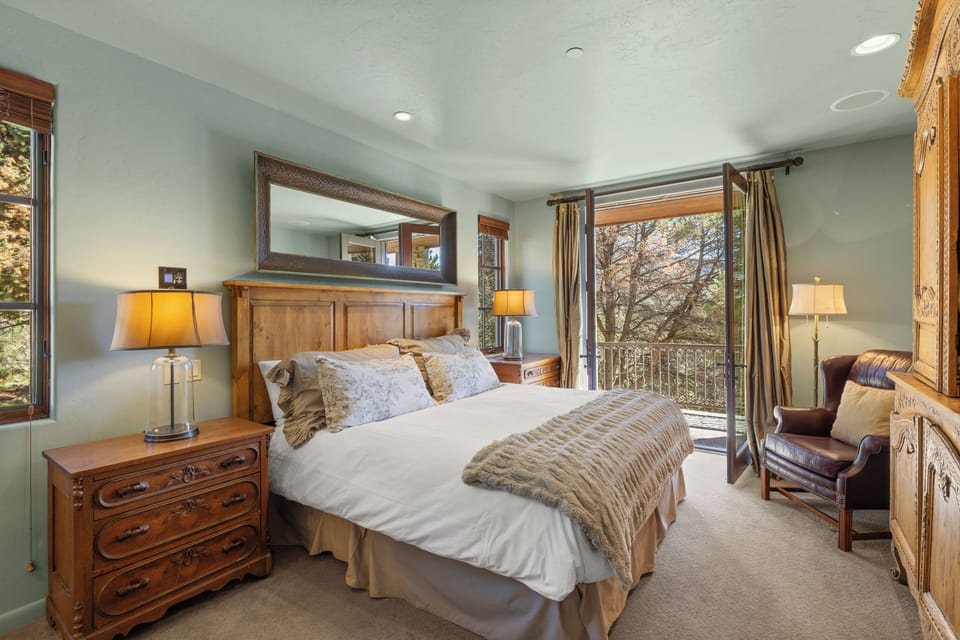 One set of stairs down from the main kitchen/dining is the first guest bedroom with king-sized bed and deck access.