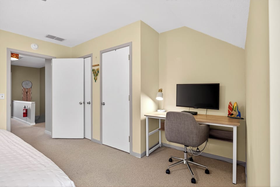 Bedroom 1: 1 King bed, Smart TV, designated workspace, large closet, and en-suite bathroom with tub/shower combo