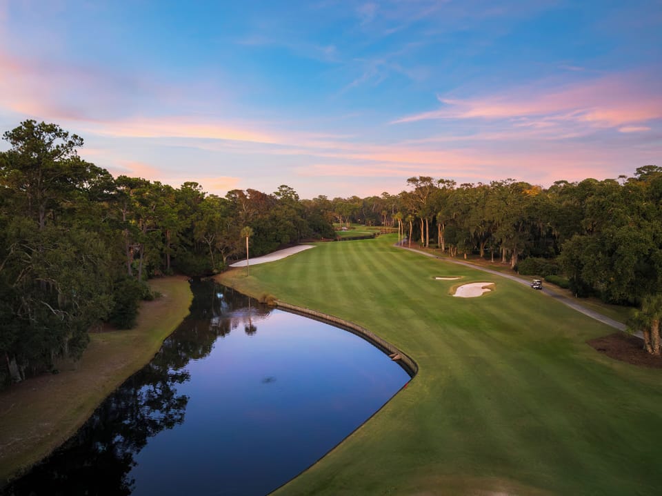 Scenic aerial of the lush golf course at sunset, just steps from your backyard.