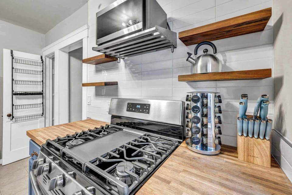 Cook with ease and style. This well-equipped kitchen brings together modern appliances, open shelving, and cozy charm perfect for crafting meals and memories alike.