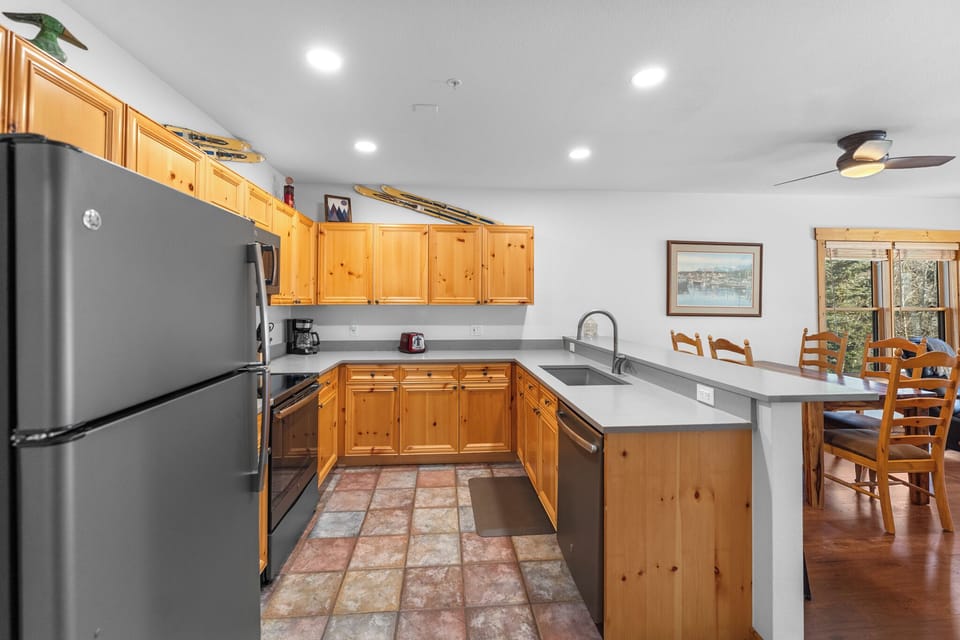 Your fully equipped kitchen features warm pine cabinets, modern appliances, and an open design perfect for preparing meals during your mountain getaway.